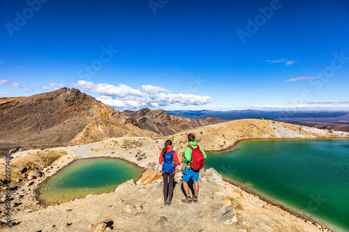 New Zealand popular tourist hiking hike in Tongariro Alpine Crossing National Park. Tramping trampers couple hikers walking on famous destination in NZ. photo
