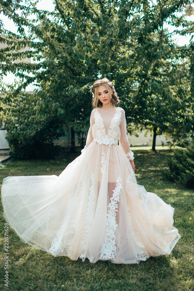 Bride in a long dress on a green background. Bright photo of a beautiful girl Bride in a long dress on a green background. Bright photo of a beautiful girl