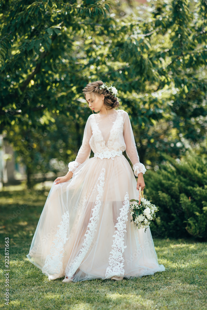 Bride in a long dress on a green background. Bright photo of a beautiful girl