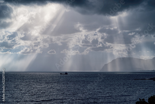 The sun's rays over the sea in the cloudy sky