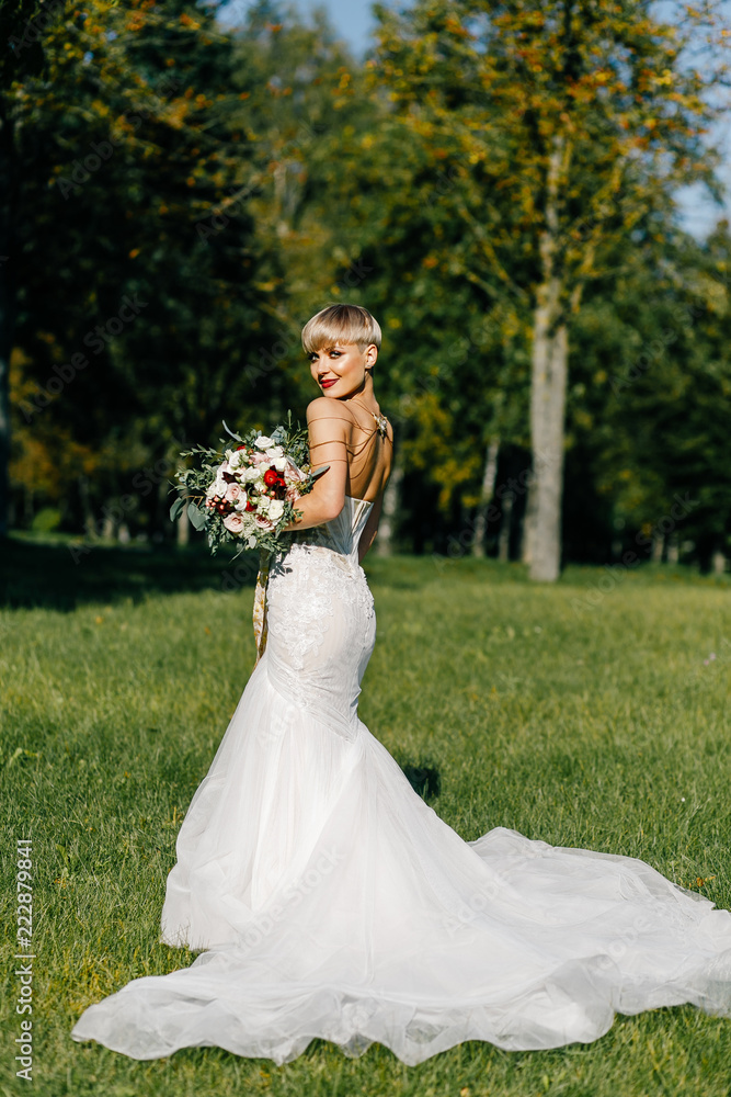 fashionable bride with short hair posing in the park