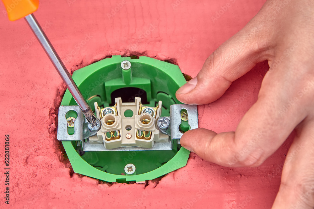 Installation of household wall socket, electrician's hands close-up. Installation of household wall socket, electrician's hands close-up.