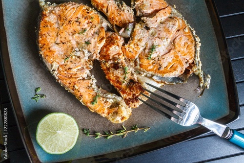 Delicious salmon steak grilled with lemon and pepper on a plate
