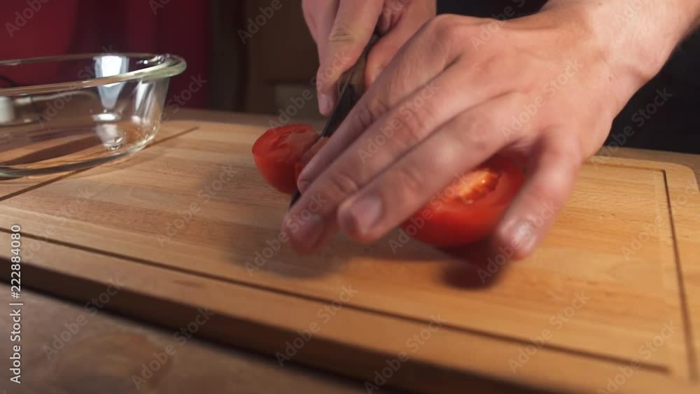 Hands cut tomatoes with knife for salad Hands cut tomatoes with knife for salad