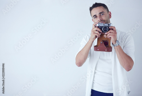 Young man with camera. Isolated over white background. photo