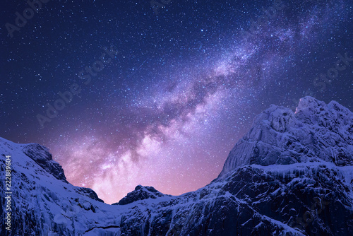 Fototapeta samoprzylepna Droga Mleczna ponad zaśnieżonymi górami. Przestrzeń. Fantastyczny widok ze śniegiem pokryte skałami i gwiaździste niebo w nocy w Nepalu. Grzbiet górski i niebo z gwiazdami w Himalajach. Krajobraz z fioletową mleczną drogą. Galaktyka
