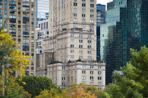 Close-up view of some skyscrapers in Manhattan and some coloured trees in the foreground. New York, USA.