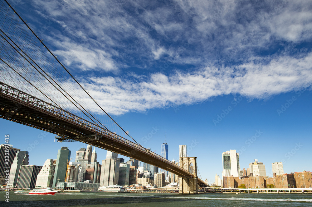 Fototapeta premium Panoramę Manhattanu z mostem Brooklyn i One World Trade Center w tle w słoneczny dzień w Nowym Jorku, USA.