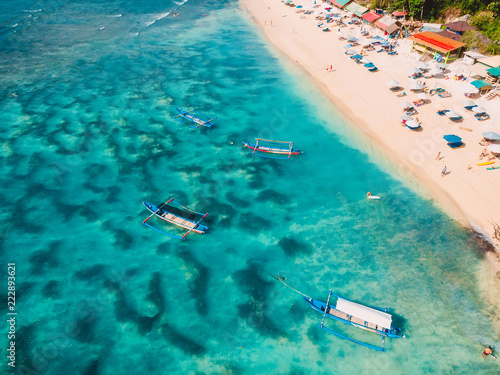 Aerial view of beach with turquoise sea water and local boats, drone shot © artifirsov