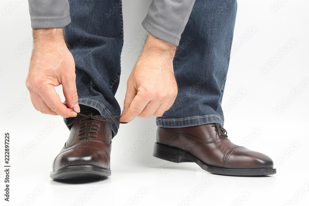 Man tying shoelaces on classic brown Oxford shoes