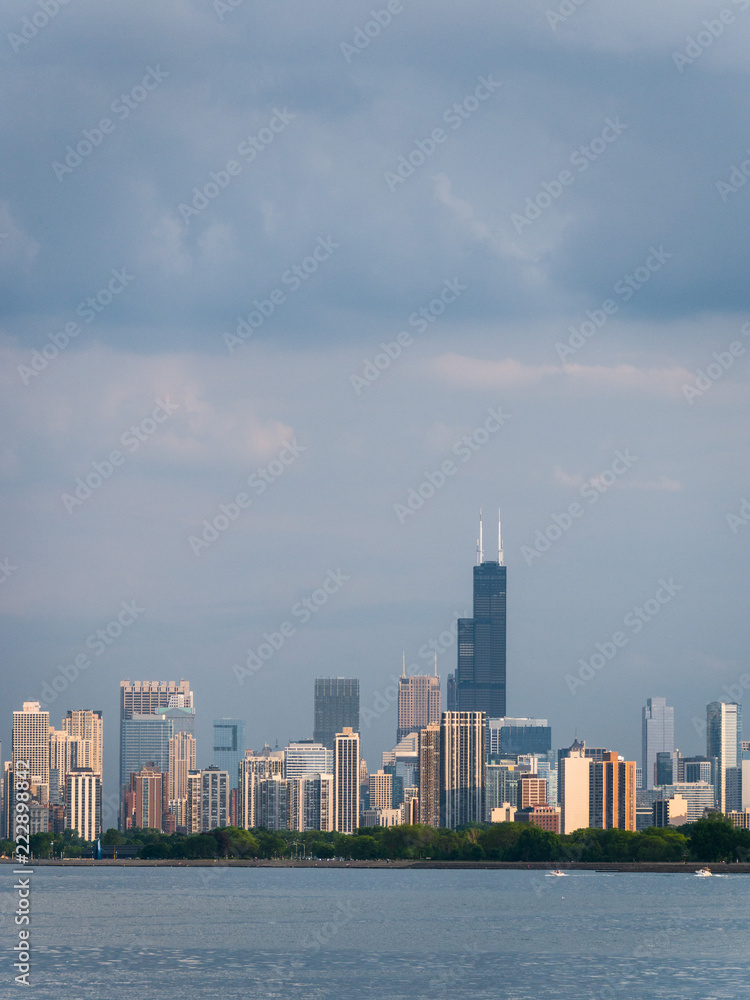 Gorgeous view of the Chicago skyline architecture with new and vintage highrise buildings across the water of Lake Michigan with fluffy clouds in the sky above.