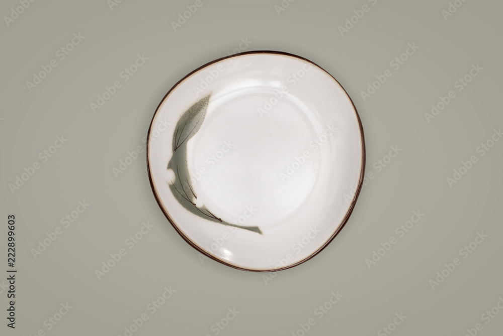 Top view-Empty white ceeamic round dish plate isolated on green background. Top view-Empty white ceeamic round dish plate isolated on green background.