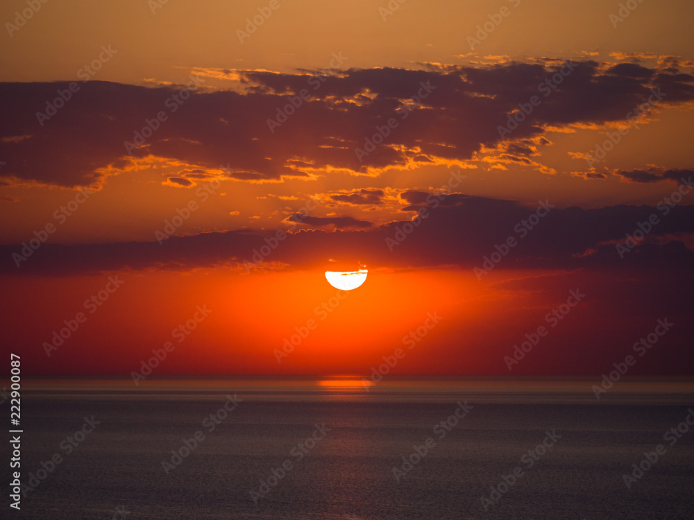 Beautiful sunrise photograph with vibrant orange and yellow colors over the dark waters of Lake Michigan in Chicago with layers of clouds in the sky above. Beautiful sunrise photograph with vibrant orange and yellow colors over the dark waters of Lake Michigan in Chicago with layers of clouds in the sky above.
