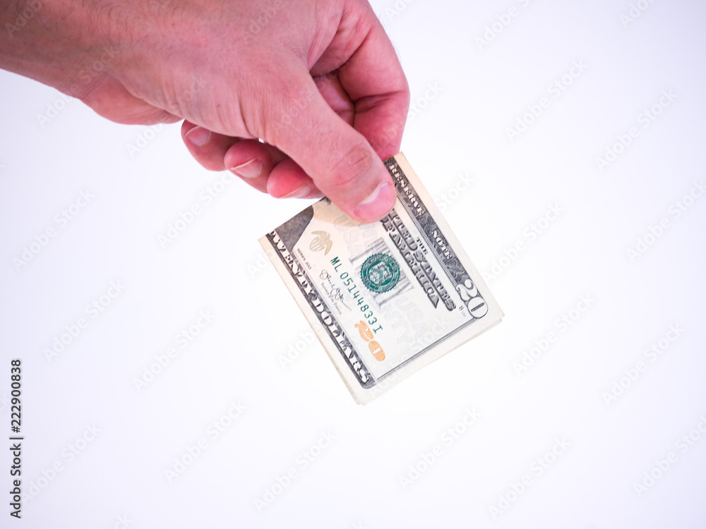Photograph of a Caucasian male hand holding a folded twenty dollar bill handing it downward isolated on a white background. Photograph of a Caucasian male hand holding a folded twenty dollar bill handing it downward isolated on a white background.