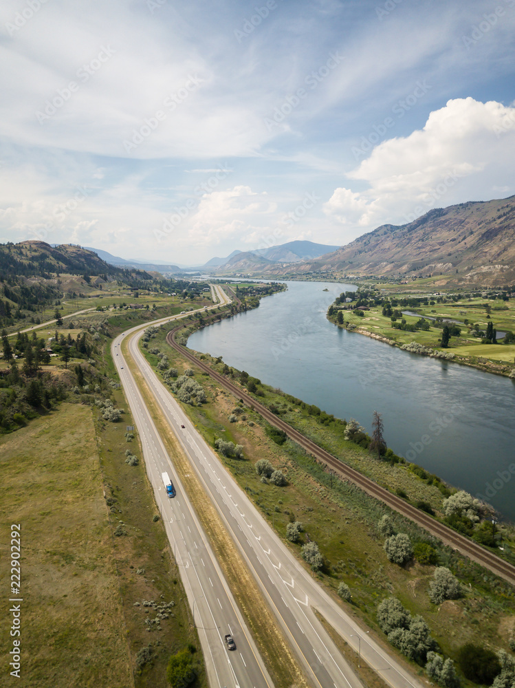 Aerial view of Trans-Canada Highway near Thompson River during a vibrant sunny summer day. Taken near Kamloops, BC, Canada.