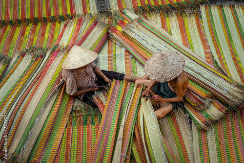 Top view of old Vietnamese lover craftsman making the traditional vietnam mats in the old traditional village at dinh yen, dong thap, vietnam, tradition artist concept photo