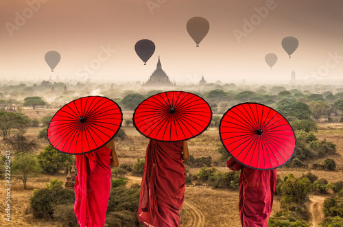 Canvas Print Back side of three Buddhist novice are walking over the Ancient Temples in Bagan
