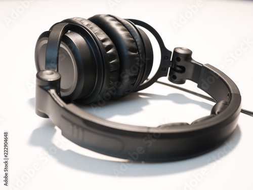 Close up photograph of black DJ style headphones isolated on a white background. © Joseph Kirsch