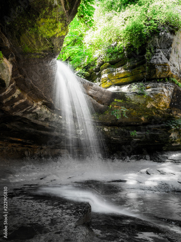 Photo of waterfall as it pours over the edge of a limestone cliff edge in the LaSalle canyon in Starved Rock State Park in Illinois