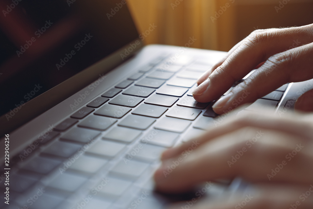 Closeup image of hands using and typing on laptop keyboard on wooden table Closeup image of hands using and typing on laptop keyboard on wooden table