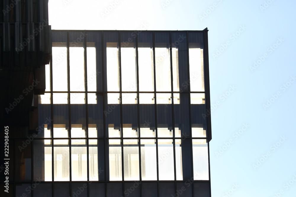 the transparent facade of the building against the sky and the sun the transparent facade of the building against the sky and the sun