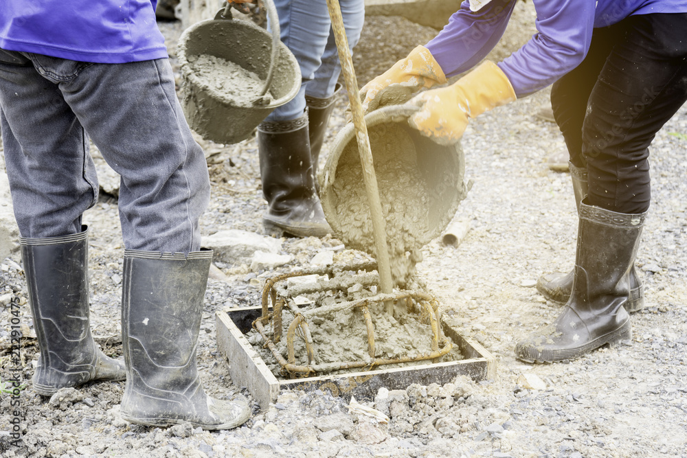 Workers are pouring concrete out of the tank to make a pile casting. Workers are pouring concrete out of the tank to make a pile casting.