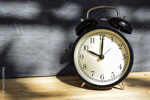 10 am/pm Back to school concept. Alarm clock on wooden with blackboard on background photo