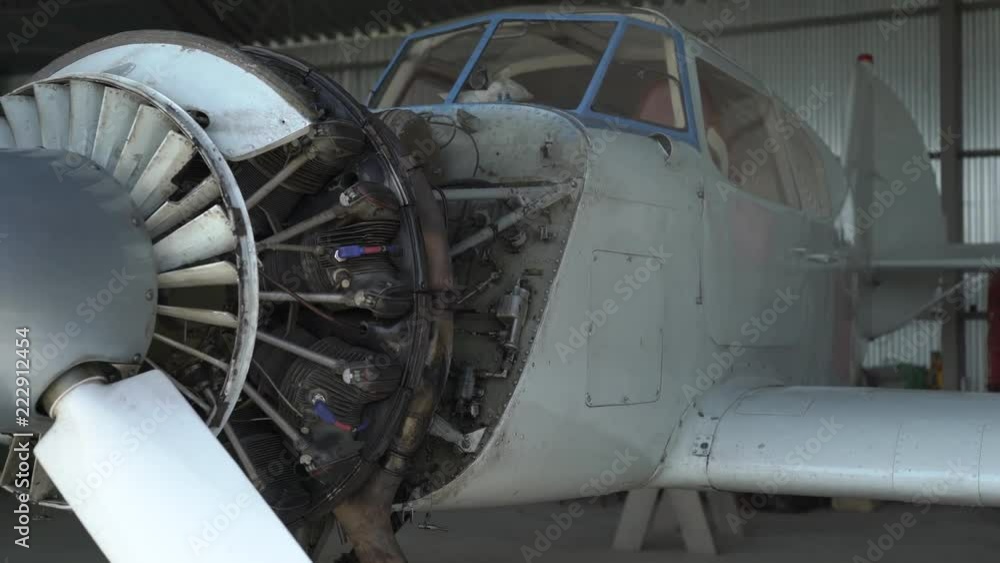 small ultralight airplane is standing in an garage of aerodrome in daytime, camera is moving around it small ultralight airplane is standing in an garage of aerodrome in daytime, camera is moving around it