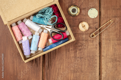 Overhead photo of sewing box with vintage pin, buttons, and copy space