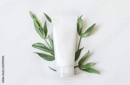 Natural organic cosmetic packaging plastic mock up with leaves and flowers. Mock-up bottle for branding and label.