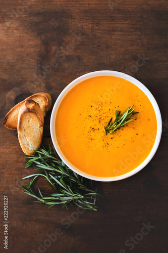 Pumpkin and carrot  Cream soup on  wooden background. Autumn cream-soup in country style. Top view. Copy space.