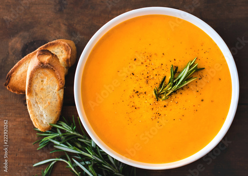 Pumpkin and carrot  Cream soup on  wooden background. Autumn cream-soup in country style. Top view. Copy space.