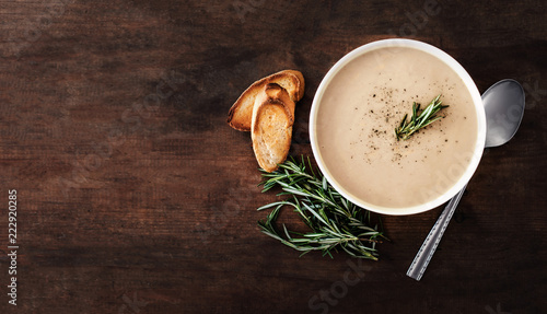 Creamy Mushroom Soup in a white bowl on rustic  wooden  table. . Top view. Copy space.