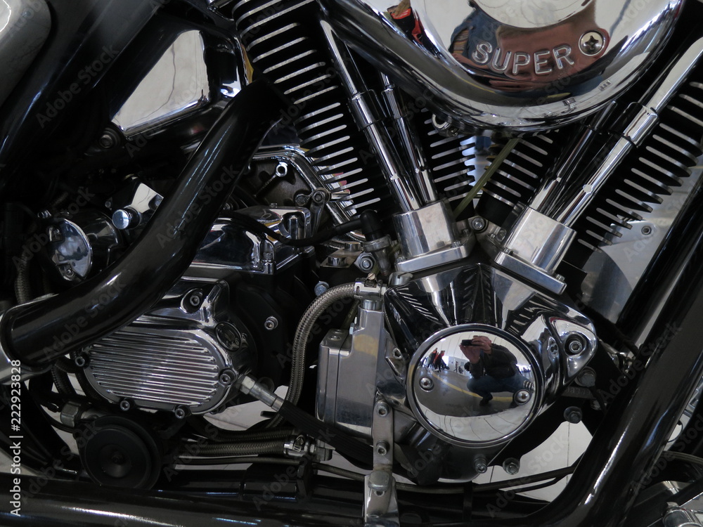Chrome motorcycle engine parts close-up. The engine and exhaust system in chrome of the motorcycle. Chrome motorcycle engine parts close-up. The engine and exhaust system in chrome of the motorcycle.
