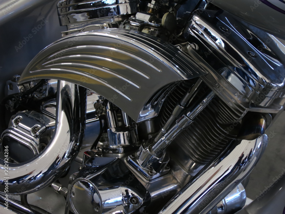 Chrome motorcycle engine parts close-up. The engine and exhaust system in chrome of the motorcycle. Chrome motorcycle engine parts close-up. The engine and exhaust system in chrome of the motorcycle.