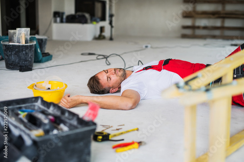 Cuadro en lienzo A man worker lying on the floor after an accident at the construction site