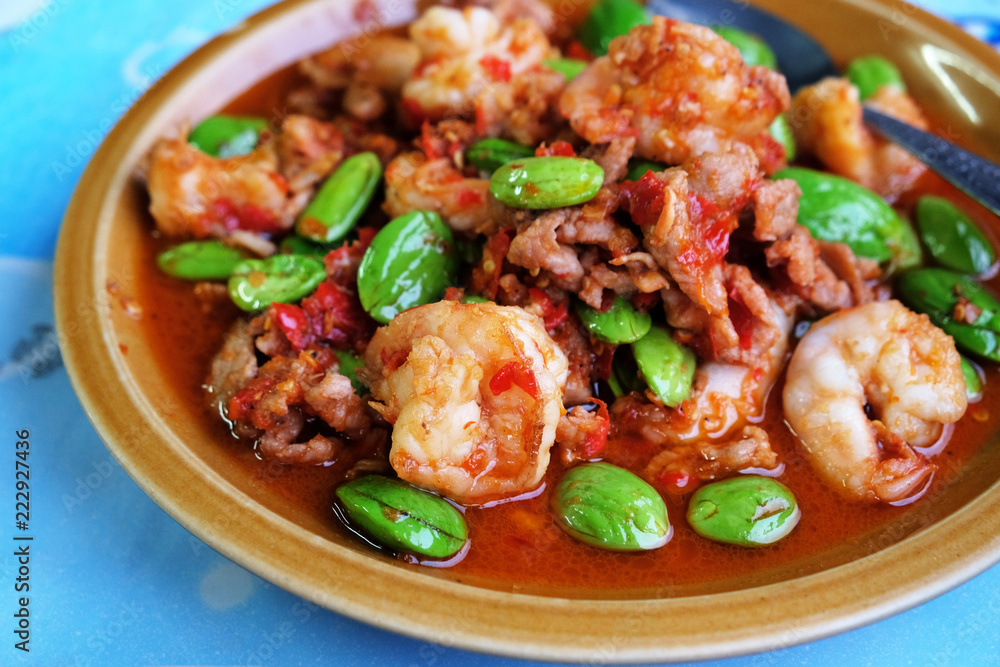 Stir-Fried Twisted Cluster Bean with Shrimps/Bitter Bean and Crispy Pork on a White Dish Over Blue Table Stir-Fried Twisted Cluster Bean with Shrimps/Bitter Bean and Crispy Pork on a White Dish Over Blue Table