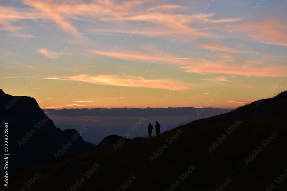 Young couple admiring the sunset in mountain. Ivan Vazov Hut, Rila Mountains, Bulgaria