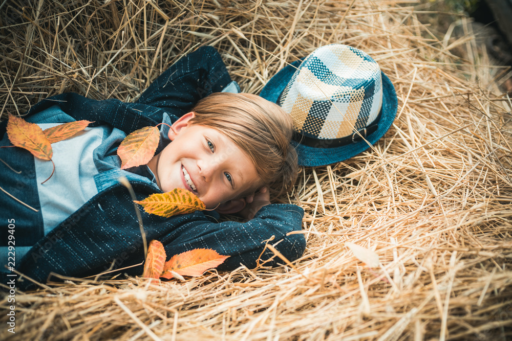 Autumn Clothing and color kids trends. Boy on a breeze in an autumn village. Autumn child boy with autumnal mood. Advertisement concept. Autumn Clothing and color kids trends. Boy on a breeze in an autumn village. Autumn child boy with autumnal mood. Advertisement concept.