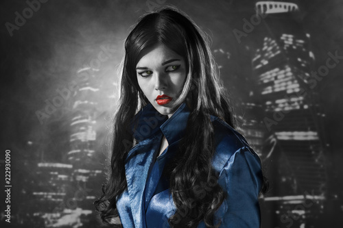 woman in a blue coat with red lips black and white in the city of sins