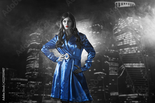 woman in a blue coat with red lips black and white in the city of sins