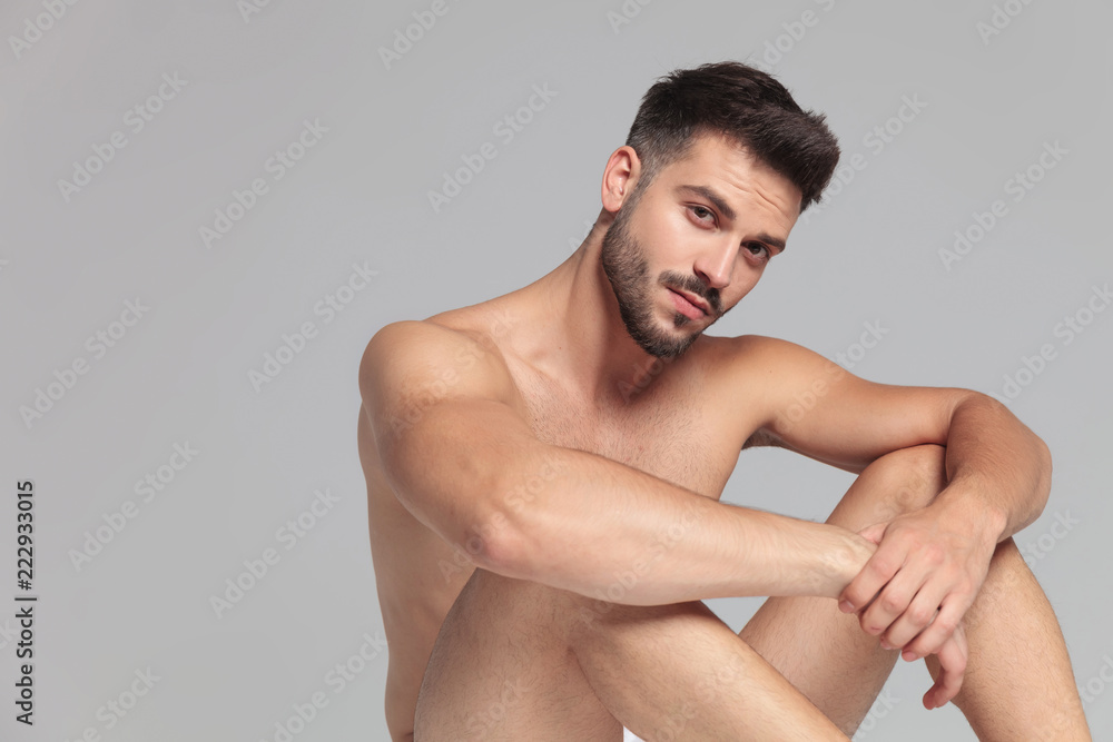 seated sexy naked man with elbows on knees is resting foto de Stock | Adobe  Stock