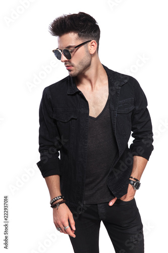 attractive casual man in black clothes looks down to side
