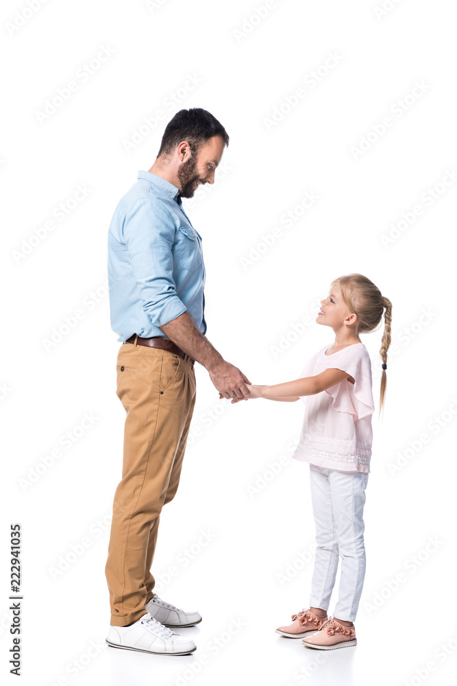 smiling father and daughter holding hands and looking at each other isolated on white smiling father and daughter holding hands and looking at each other isolated on white
