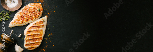 Foto Grilled chicken breast served on black slate