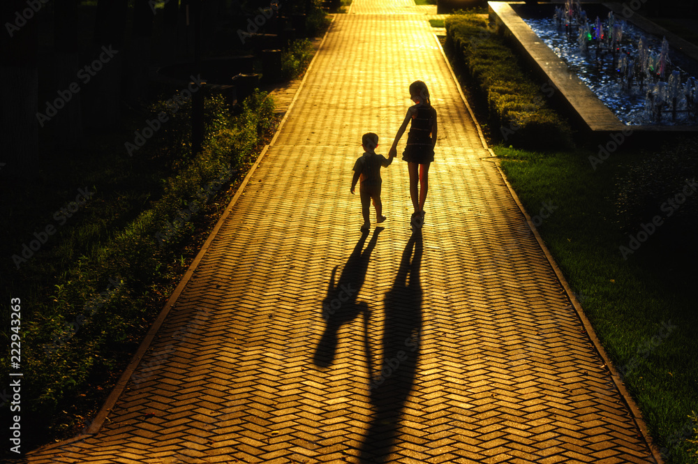 children walk along the road towards the sun