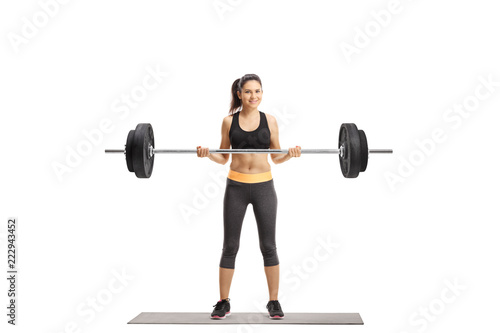 Young athletic female lifting a barbell