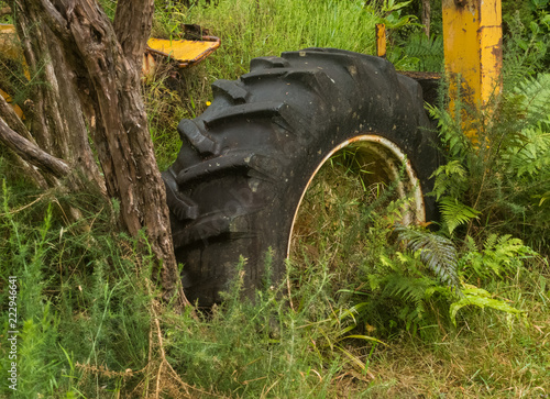 Plakat old rusty mowing machine in dense grass.