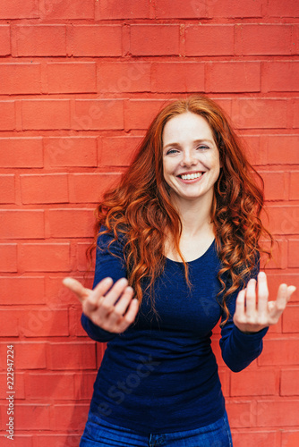 Obraz na płótnie Excited smiling woman standing in front of wall