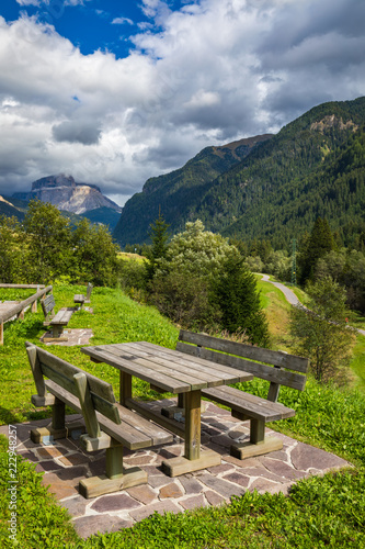 Nature landscape. Amazing view on Alps, valley and mountains at summer. It's time for lunch in the mountains. Picnic table in Dolomites mountains, wooden bench in the mountain valley.